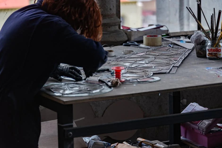 Artisan restaurateur de vitraux dans un atelier d'art sacré